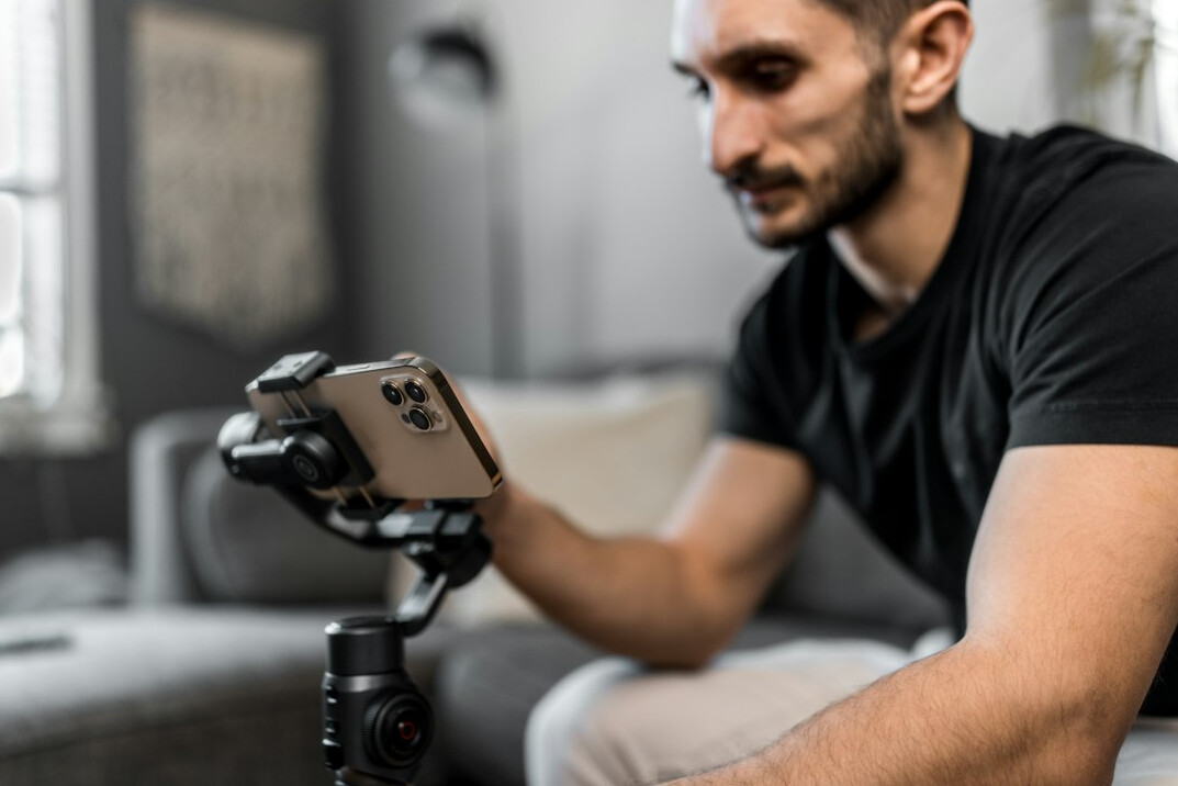 Young content creator filming a vlog with a smartphone on a gimbal
